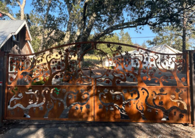 Bell Curve Bi-Parting Driveway Gate - Natural Patina Bare Metal w/ Open Grape Vine Design Top & Reverse Cut Out Bottom. Companion Pedestrian Gate PG052